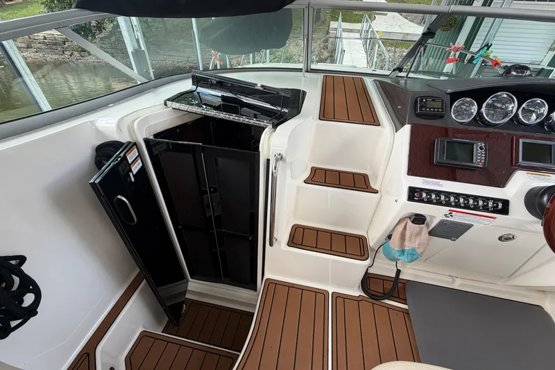 Slide: The Image of 2012 Sea Ray Sundancer 310 cockpit with wood accents and control panel. - 20