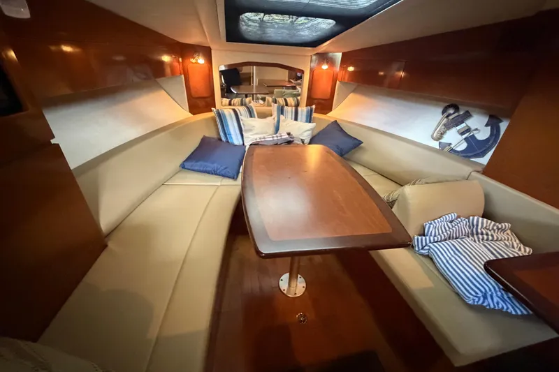 Slide: The Image of Interior of 2012 Sea Ray Sundancer 310 yacht with cozy seating and wooden table. - 24