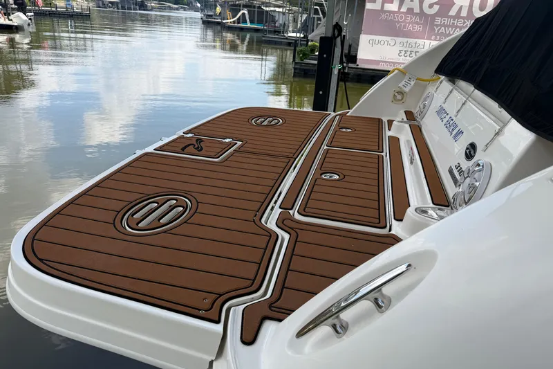 Slide: The Image of 2012 Sea Ray Sundancer 310 swim platform with teak-style decking at a marina. - 3