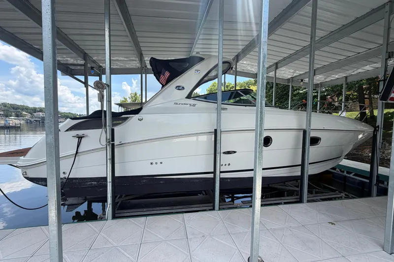 The Image of 2012 Sea Ray Sundancer 310 boat docked under a covered marina. - 0