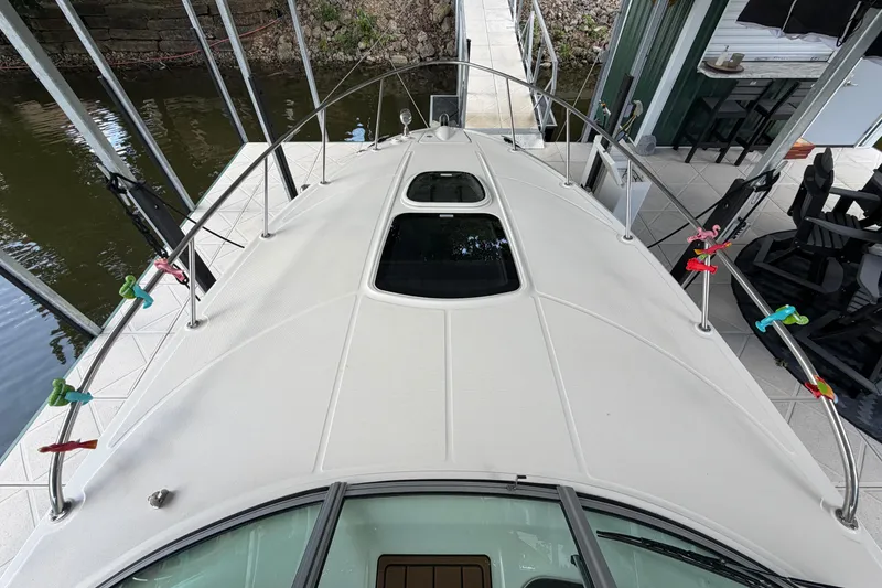 Slide: The Image of 2012 Sea Ray Sundancer 310 boat deck with colorful clips, docked by the water. - 21