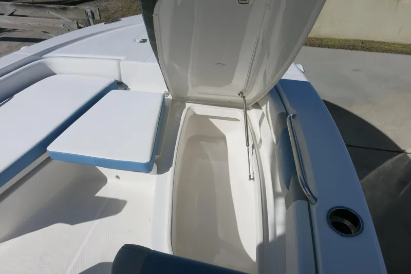 Slide: The Image of 2026 Robalo 206 Cayman boat interior with open storage compartment and cushioned seating. - 15
