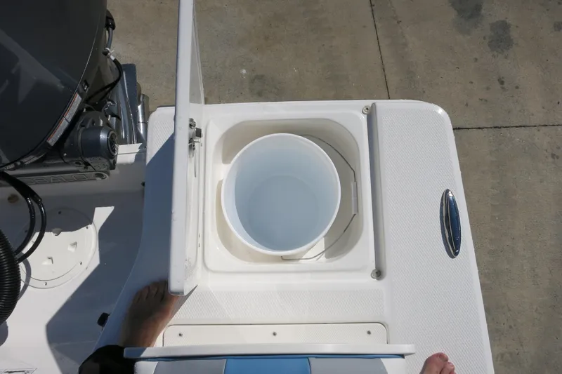 Slide: The Image of 2026 Robalo 206 Cayman boat with open storage compartment and bucket on deck. - 10