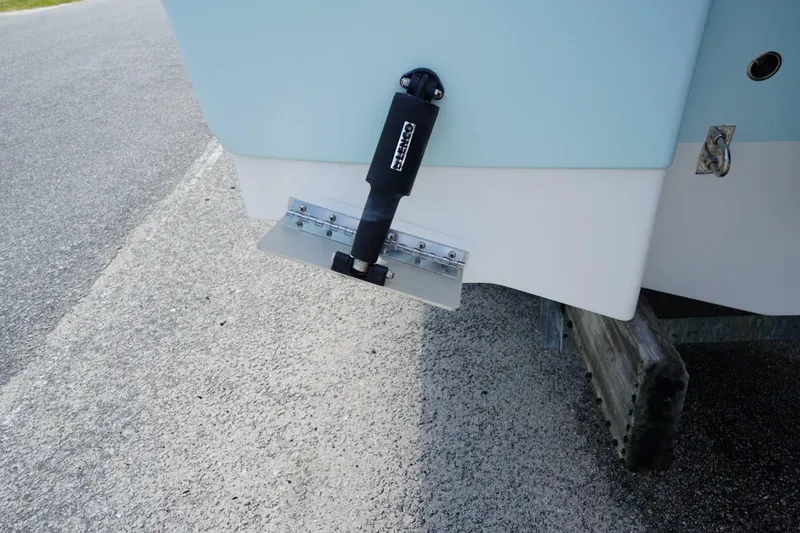 Slide: The Image of 2025 Robalo R207 Dual Console boat with trim tab detail on trailer. - 18