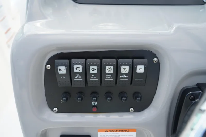 Slide: The Image of Control panel of 2025 Robalo R207 Dual Console boat with labeled switches. - 14