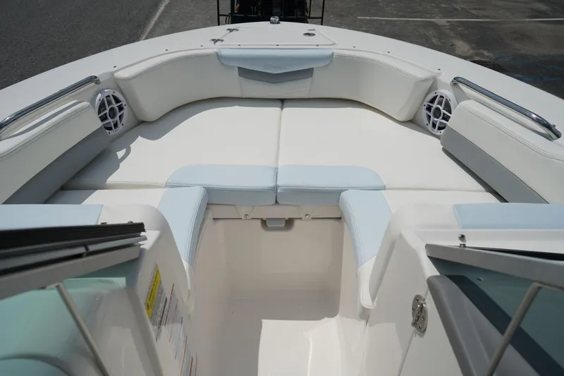 Slide: The Image of 2025 Robalo R207 Dual Console boat interior with white seating and speakers. - 5