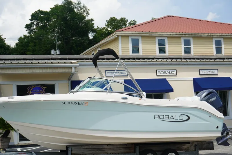 The Image of 2025 Robalo R207 Dual Console boat displayed outside dealership. - 0