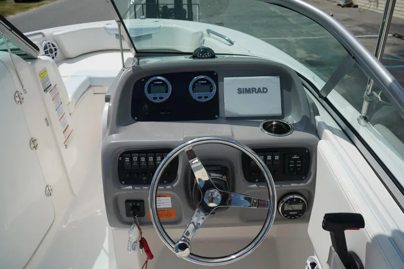 Slide: The Image of 2025 Robalo R207 Dual Console boat dashboard with steering wheel and Simrad display. - 3
