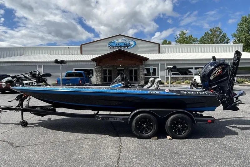 Slide: The Image of 2026 Skeeter ZXE20 boat parked outside a marine dealership under a partly cloudy sky. - 4