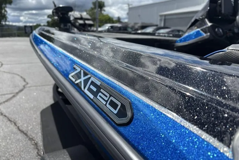 Slide: The Image of 2026 Skeeter ZXE20 boat with sparkling blue finish under cloudy sky. - 7