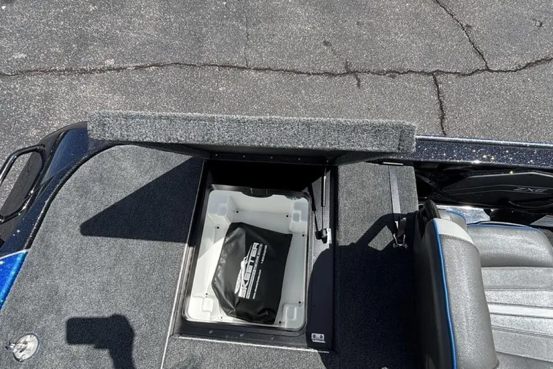 Slide: The Image of 2026 Skeeter ZXE20 boat storage compartment with carpeted lid and interior bag. - 40