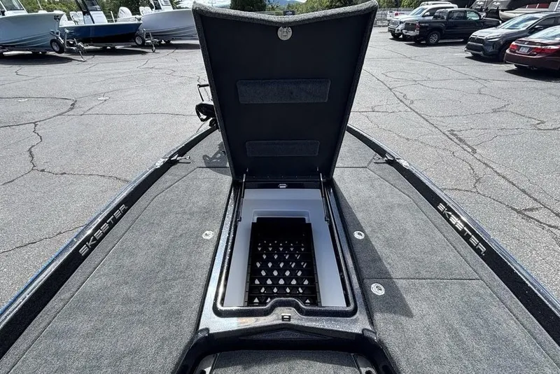 Slide: The Image of 2026 Skeeter ZXE20 boat with open storage compartment in a parking lot. - 17