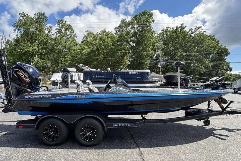 Slide: The Image of 2026 Skeeter ZXE20 boat with trailer, parked outdoors under a blue sky. - 53