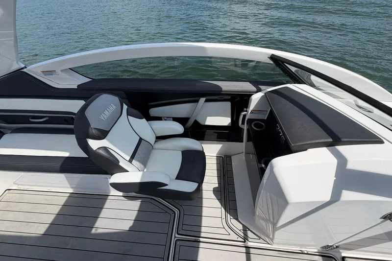 Slide: The Image of 2021 Yamaha Boats 275SD interior with sleek seating and modern dashboard on water. - 15