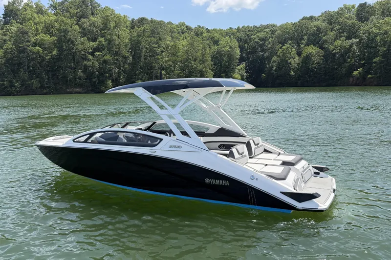 Slide: The Image of 2021 Yamaha Boats 275SD on a serene lake with lush forest backdrop. - 4