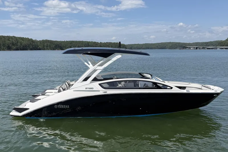 Slide: The Image of 2021 Yamaha Boats 275SD on a serene lake with lush green shoreline. - 7