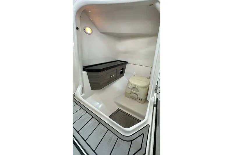 Slide: The Image of Interior of 2021 Yamaha Boats 275SD, featuring compact marine toilet and storage. - 22