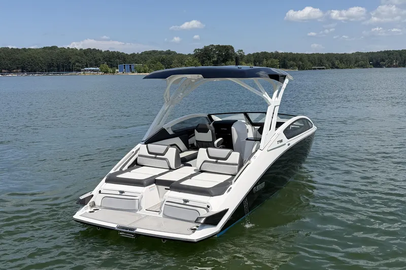 Slide: The Image of 2021 Yamaha Boats 275SD on a serene lake under a clear blue sky. - 6