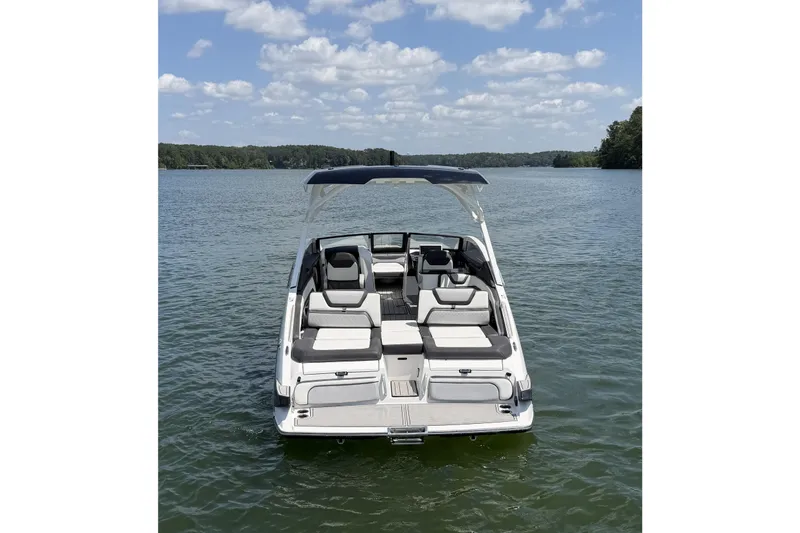 Slide: The Image of 2021 Yamaha Boats 275SD on a serene lake under a partly cloudy sky. - 5