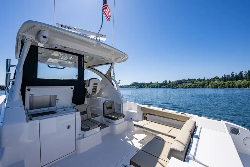 Slide: The Image of 2021 Pursuit OS 355 Offshore boat interior with seating, grill, and scenic water view. - 23
