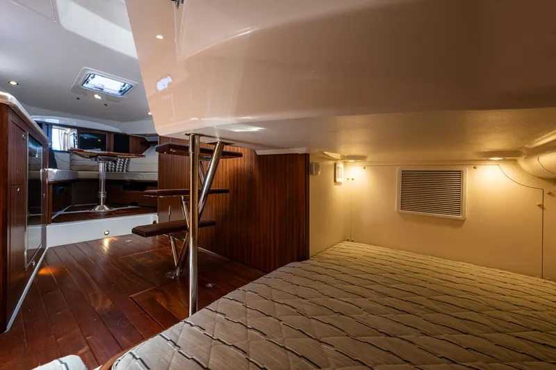 Slide: The Image of Interior of 2021 Pursuit OS 355 Offshore boat, featuring wood accents and cozy sleeping area. - 14