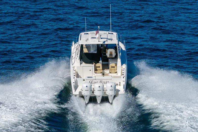 Slide: The Image of 2021 Pursuit OS 355 Offshore boat cruising on open water, rear view. - 3