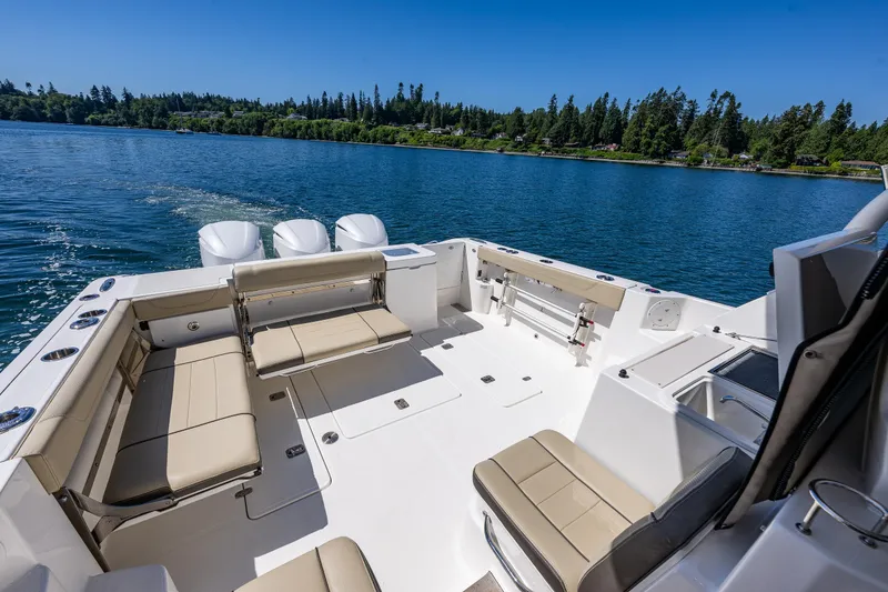 Slide: The Image of 2021 Pursuit OS 355 Offshore boat with spacious seating on a serene lake. - 17
