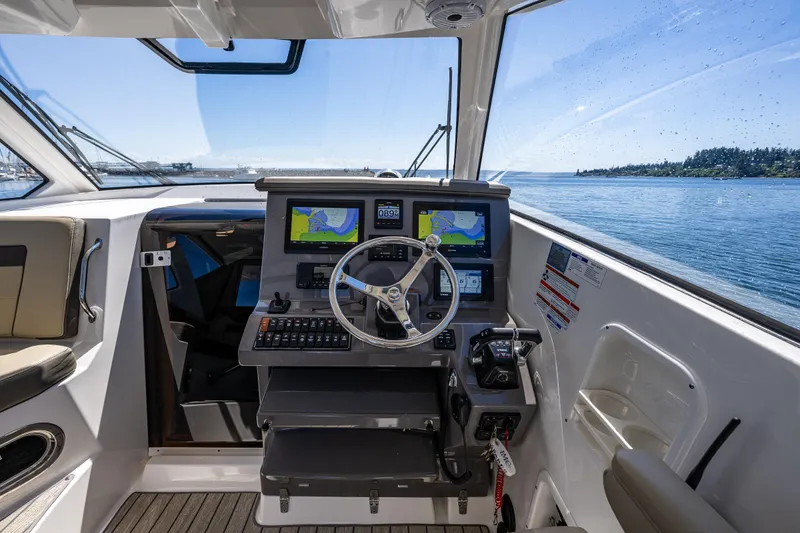 Slide: The Image of Helm of 2021 Pursuit OS 355 Offshore boat with navigation screens and steering wheel. - 18