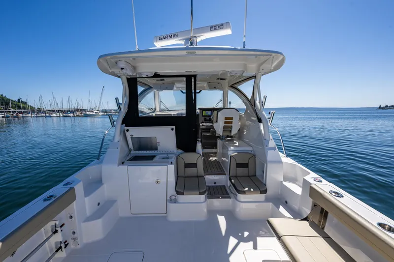 Slide: The Image of 2021 Pursuit OS 355 Offshore boat interior with seating, helm, and ocean view. - 24