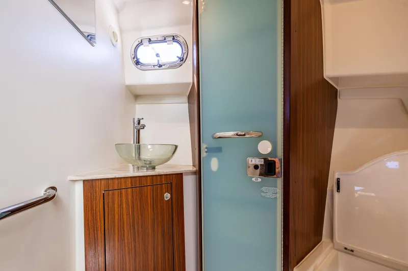 Slide: The Image of 2021 Pursuit OS 355 Offshore yacht bathroom with glass sink and modern fixtures. - 9