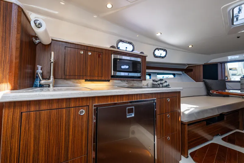 Slide: The Image of Luxurious interior of 2021 Pursuit OS 355 Offshore yacht with modern kitchen and seating area. - 16