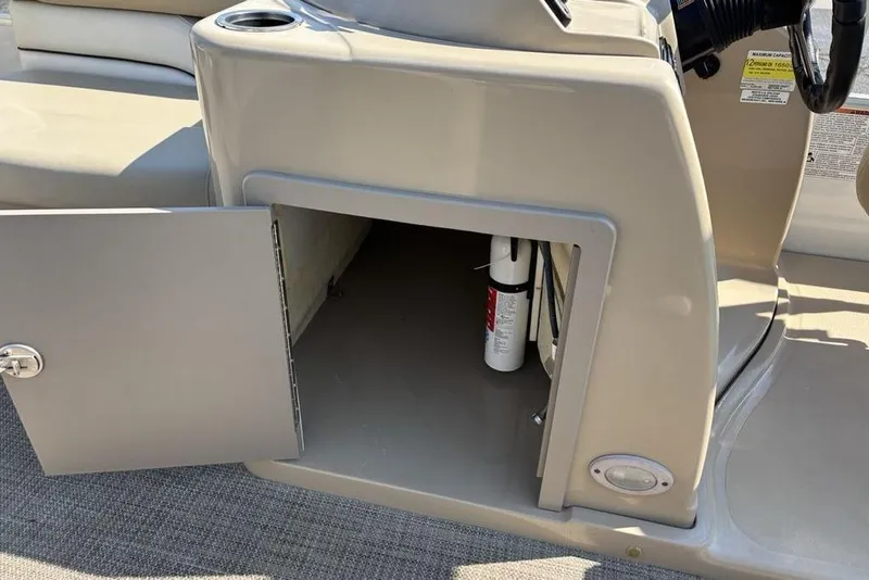 Slide: The Image of Open storage compartment on a 2016 SunChaser 8525 boat, featuring a fire extinguisher. - 26