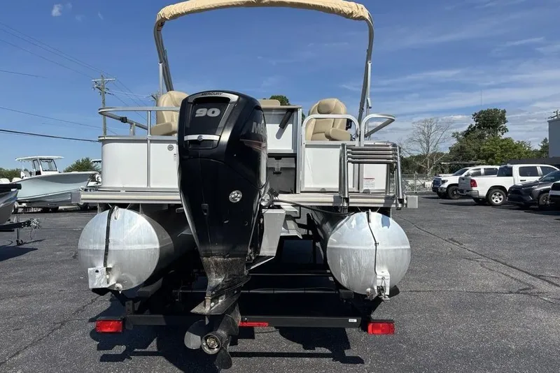 Slide: The Image of 2016 SunChaser 8525 pontoon boat with Mercury 90 engine, parked on asphalt lot. - 25