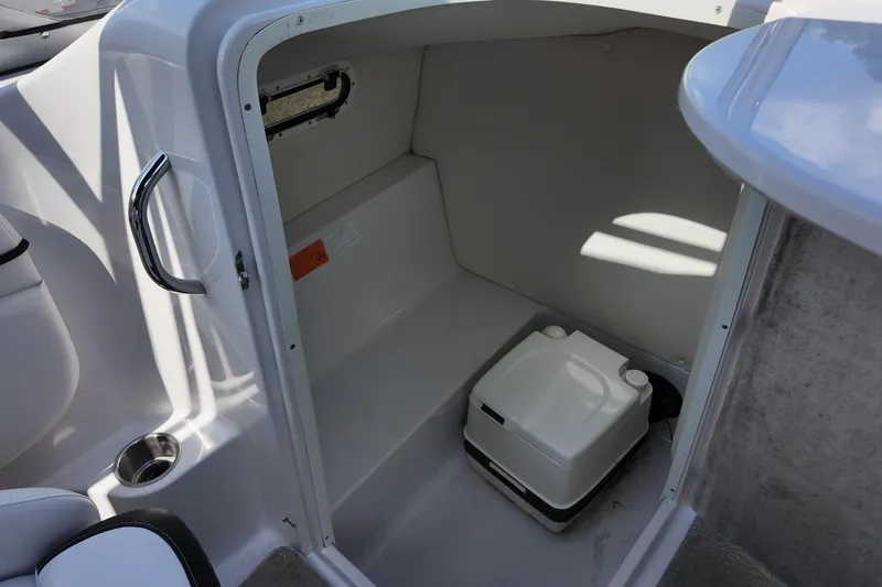 Slide: The Image of 2009 Four Winns F224 boat interior with compact portable toilet and storage space. - 19