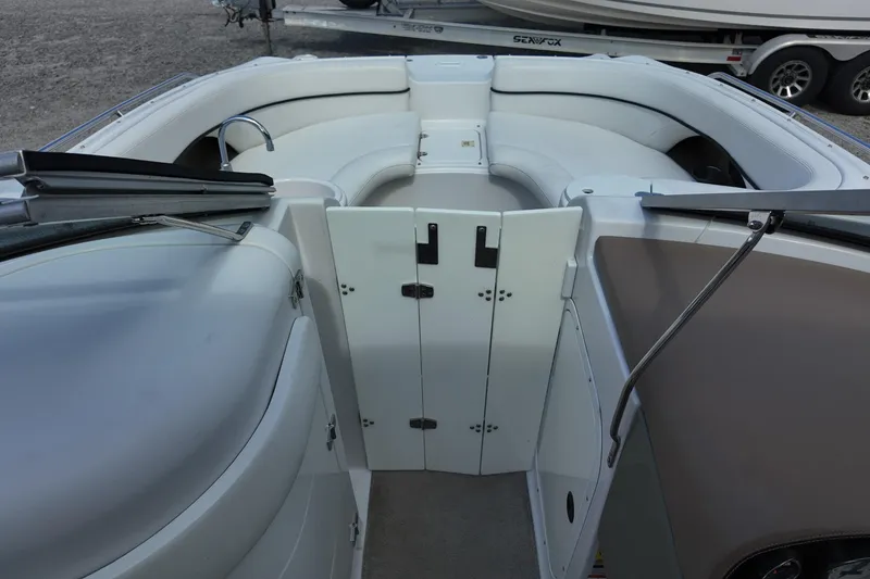 Slide: The Image of 2009 Four Winns F224 boat interior with white seating and storage compartments. - 16