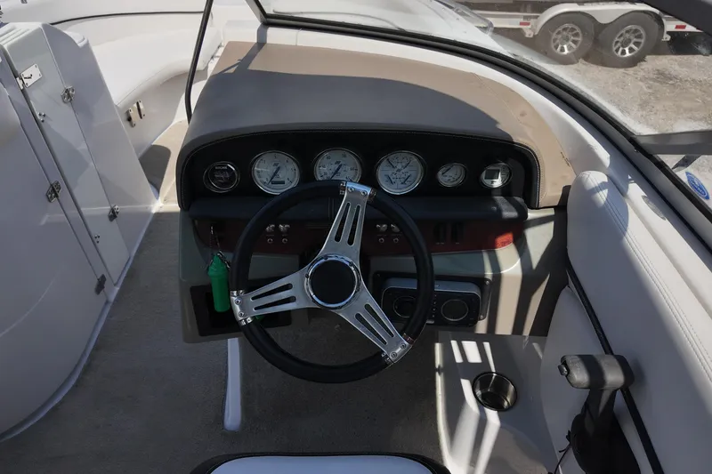 Slide: The Image of 2009 Four Winns F224 boat dashboard with steering wheel and gauges. - 18