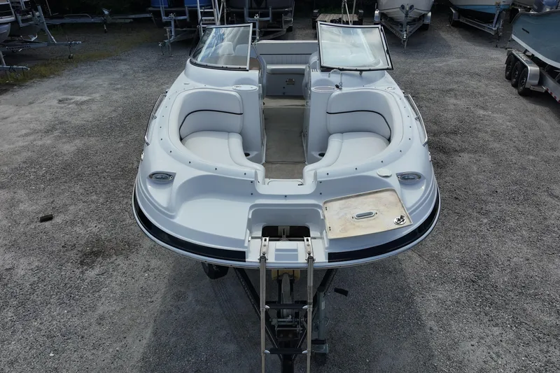 Slide: The Image of 2009 Four Winns F224 boat with spacious seating, displayed on a gravel lot. - 8