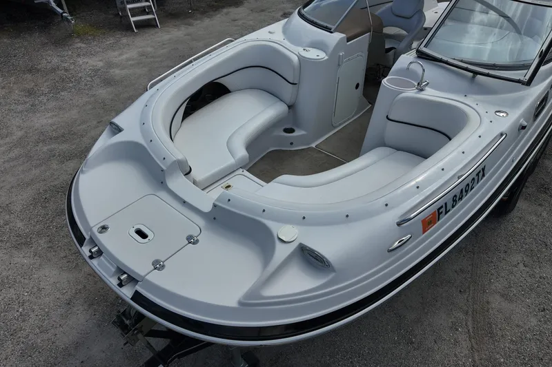 Slide: The Image of 2009 Four Winns F224 boat with spacious seating and sleek design, parked on gravel. - 9