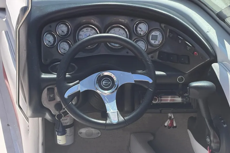 Slide: The Image of Dashboard of a 2013 Crownline 21 SS boat with steering wheel and gauges. - 2