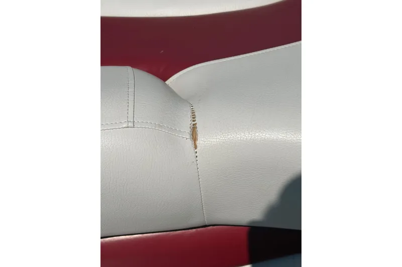 Slide: The Image of Torn upholstery on 2013 Crownline 21 SS boat seat, white and red leather. - 13