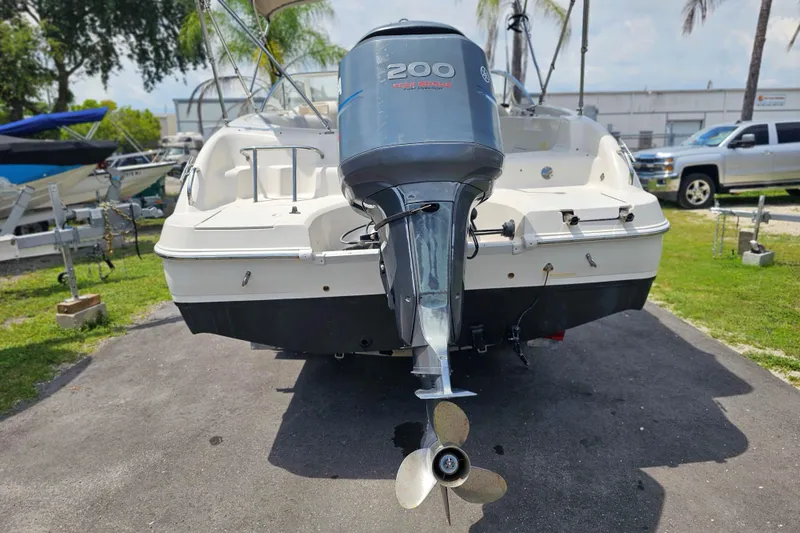 Slide: The Image of 2006 Hurricane SunDeck 237 DC OB boat with Yamaha 200 outboard motor, parked outdoors. - 6