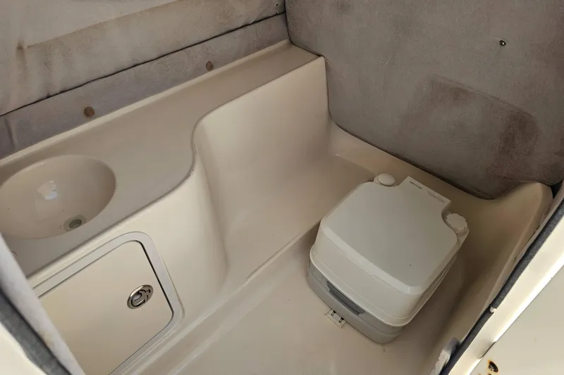 Slide: The Image of 2006 Hurricane SunDeck 237 DC OB boat interior with portable toilet and sink. - 24