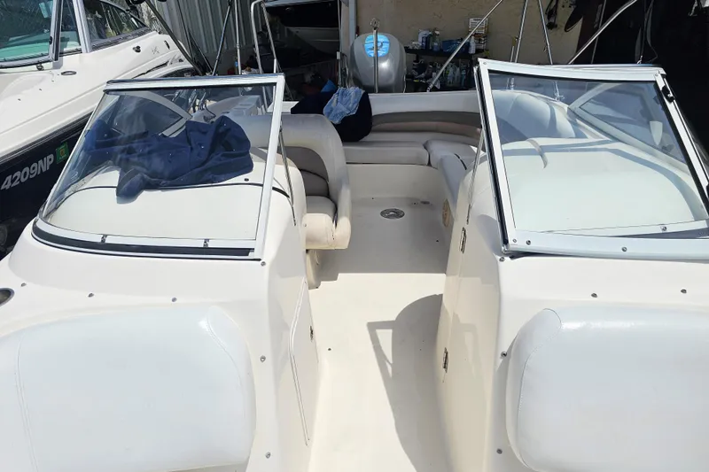 Slide: The Image of 2006 Hurricane SunDeck 237 DC OB boat interior with dual windshields and seating area. - 15