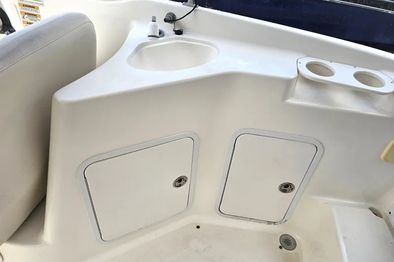 Slide: The Image of 2006 Hurricane SunDeck 237 DC OB boat interior with sink and storage compartments. - 23