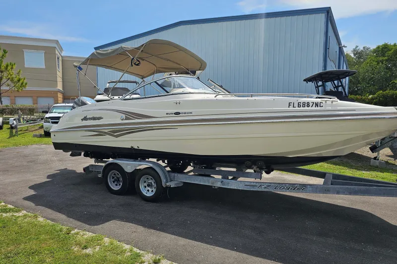 Slide: The Image of 2006 Hurricane SunDeck 237 DC OB boat on trailer, parked outdoors. - 3