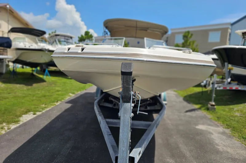 Slide: The Image of 2006 Hurricane SunDeck 237 DC OB boat on trailer, parked outdoors under blue sky. - 7