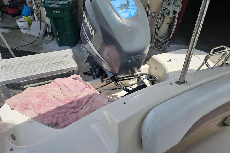 Slide: The Image of 2006 Hurricane SunDeck 237 DC OB with Yamaha 200 outboard motor in a garage setting. - 26