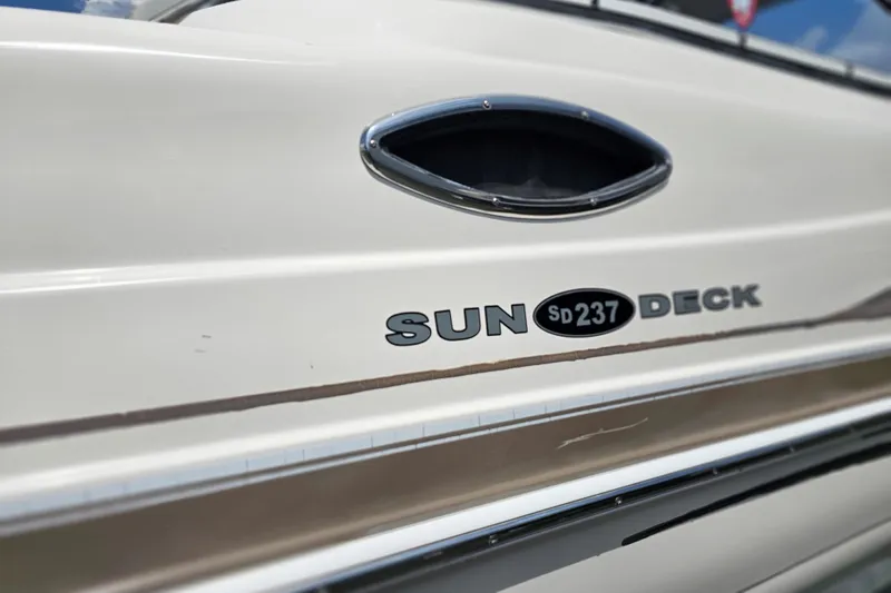 Slide: The Image of 2006 Hurricane SunDeck 237 DC OB boat side view with model name and logo. - 9
