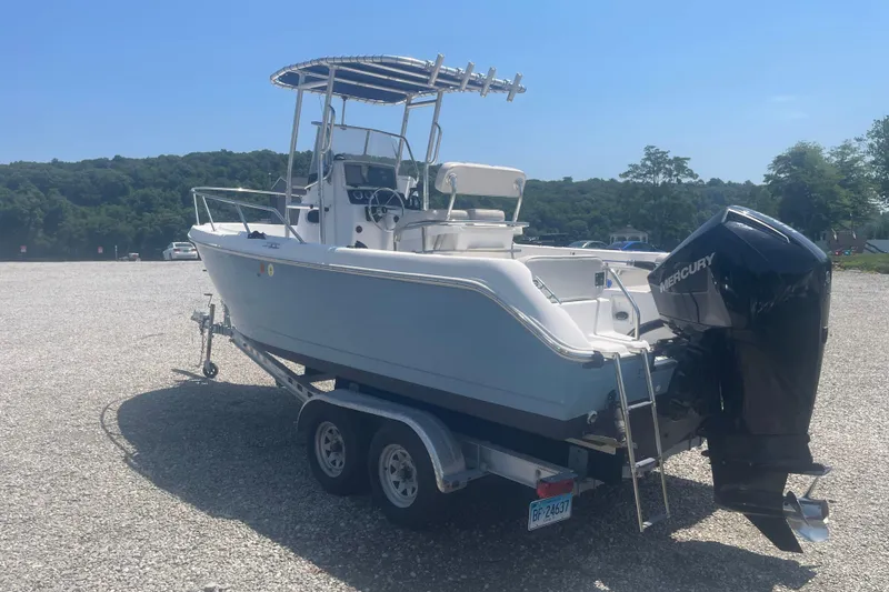 Slide: The Image of 2001 Boston Whaler 21 Outrage boat on trailer, featuring Mercury outboard motor. - 3