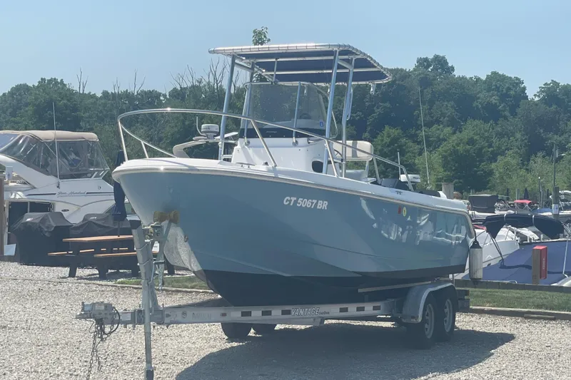 The Image of 2001 Boston Whaler 21 Outrage boat on trailer, parked in marina under clear sky. - 0